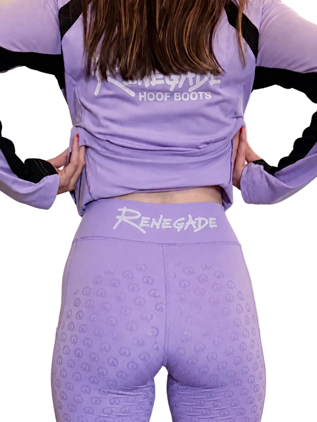 A model from behind wearing a lavender purple Renegade Hoof Boots athletic set, featuring a long-sleeve top with black sleeve accents and matching high-waisted leggings with a white logo on the waistband.